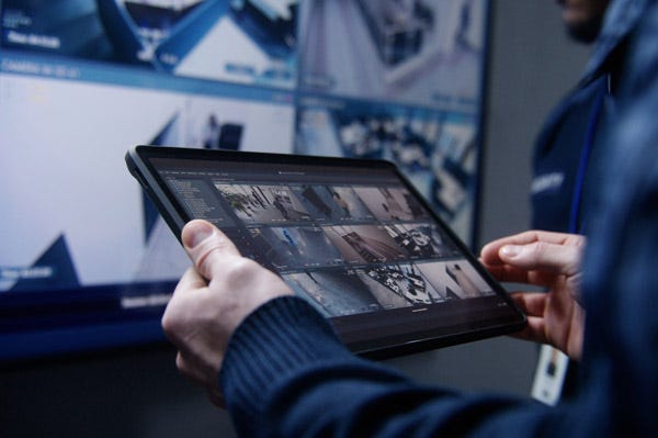 Man holding a tablet with multiple camera views on 