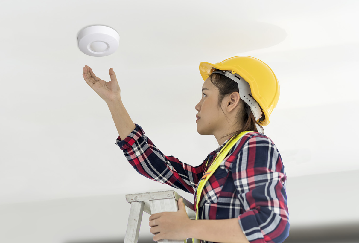 Woman installing detector